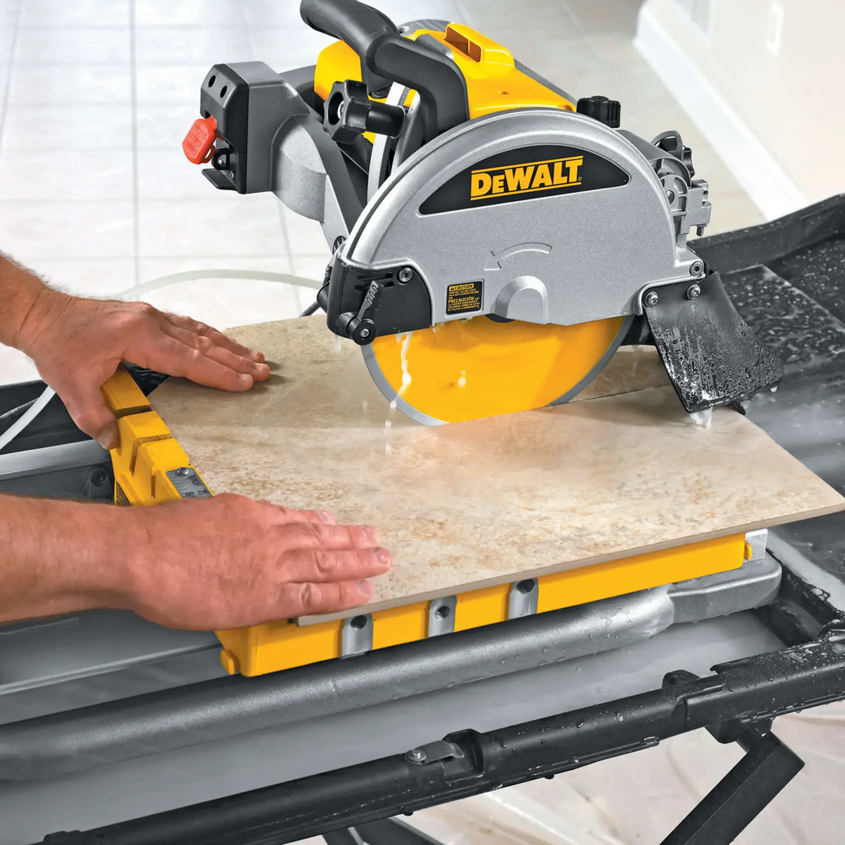 A person is using a DEWALT D24000 tile saw to cut a ceramic tile. The tile saw is mounted on a work stand, and water is used to cool the blade during cutting.