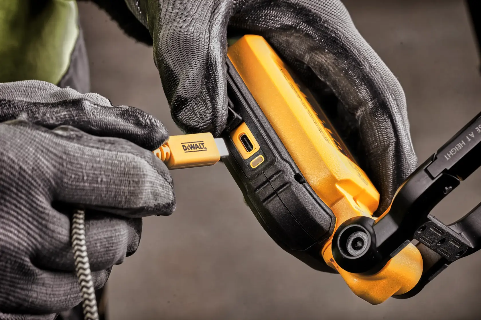 Une lampe de travail LED portable DEWALT avec un boîtier noir et jaune, comprenant un panneau lumineux rectangulaire avec plusieurs LED et un support pliable.