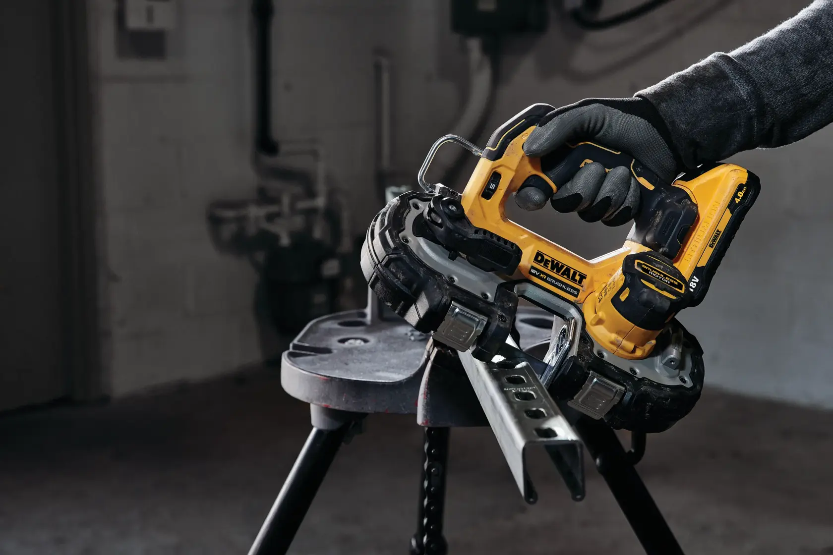 DEWALT cordless bandsaw cutting a metal piece, operated by a gloved hand in a workshop.