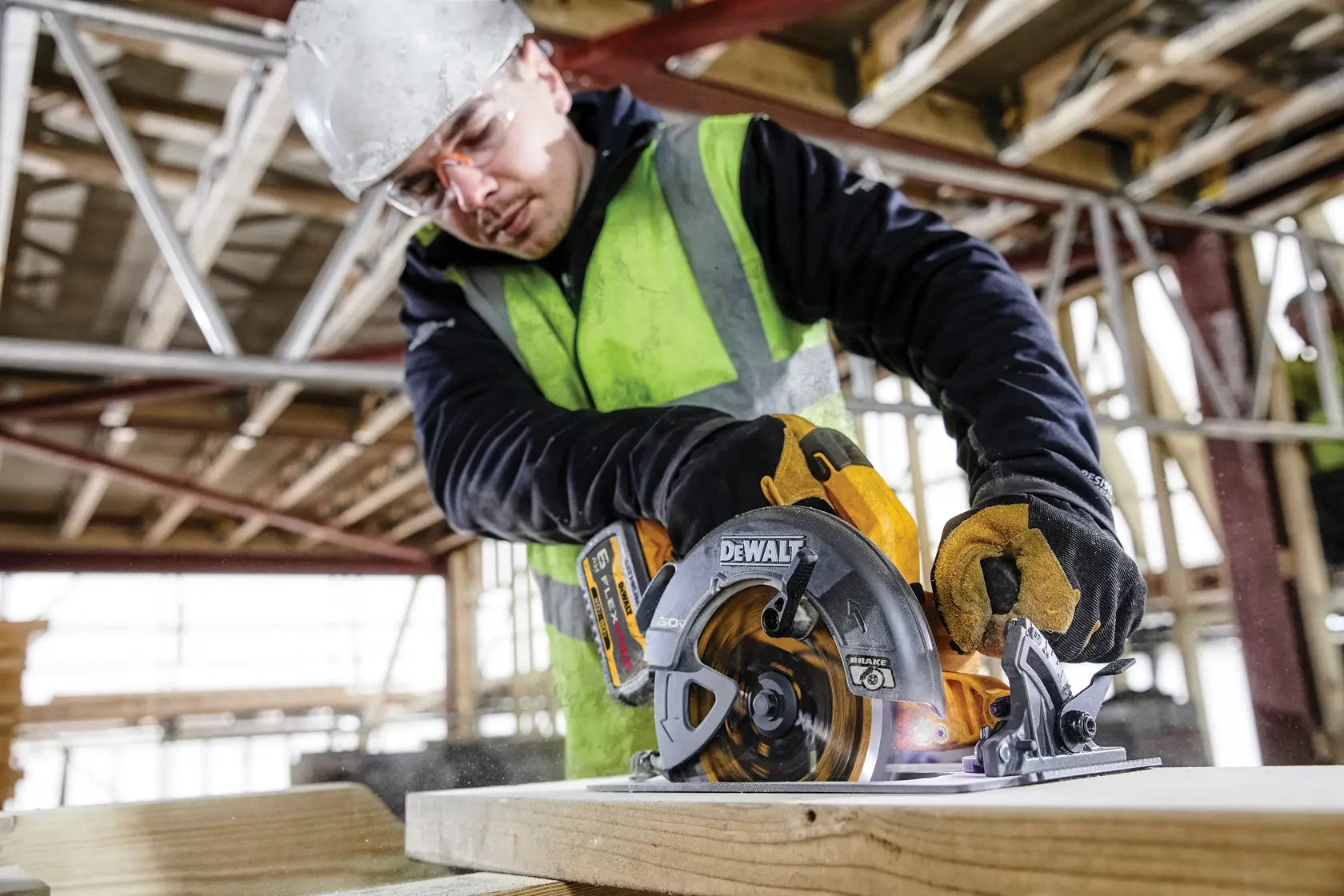 Photo of worker using DEWALT circular saw, SKUs DCS578T2, DCS578T2-GB on wood at construction site.
