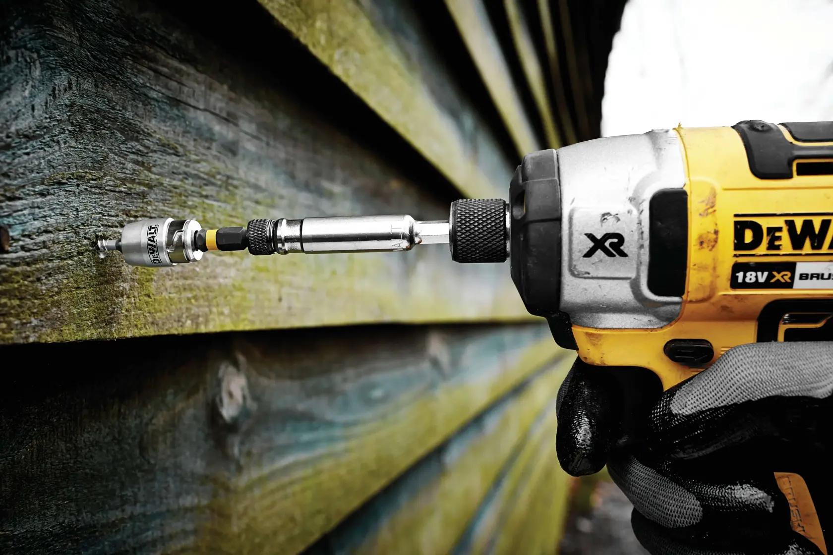 Destornillador de impacto DEWALT atornilla en revestimiento de madera exterior.