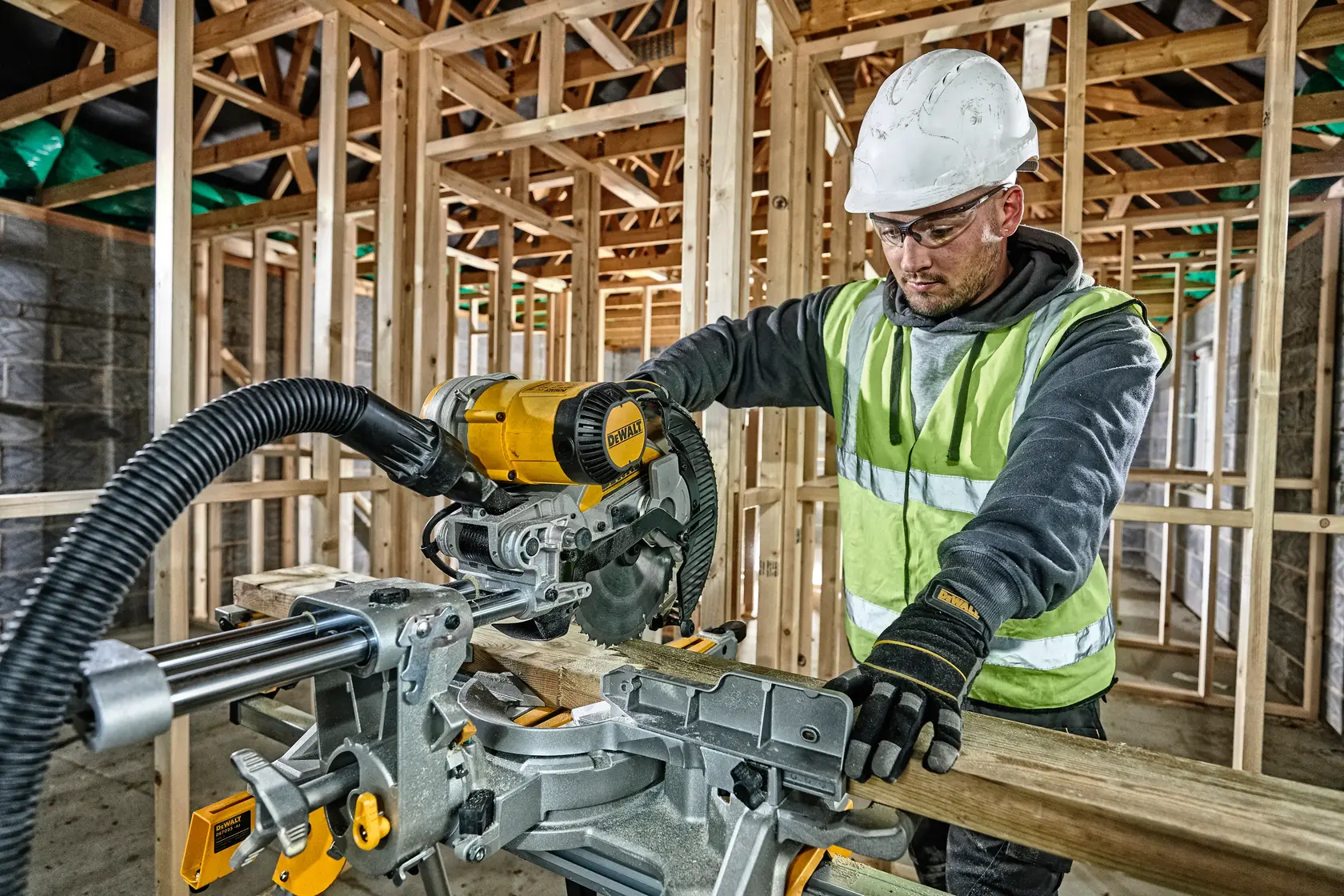 Photo of DEWALT DWS727, DWS727-LX miter saw in use on construction site, worker cutting wood.