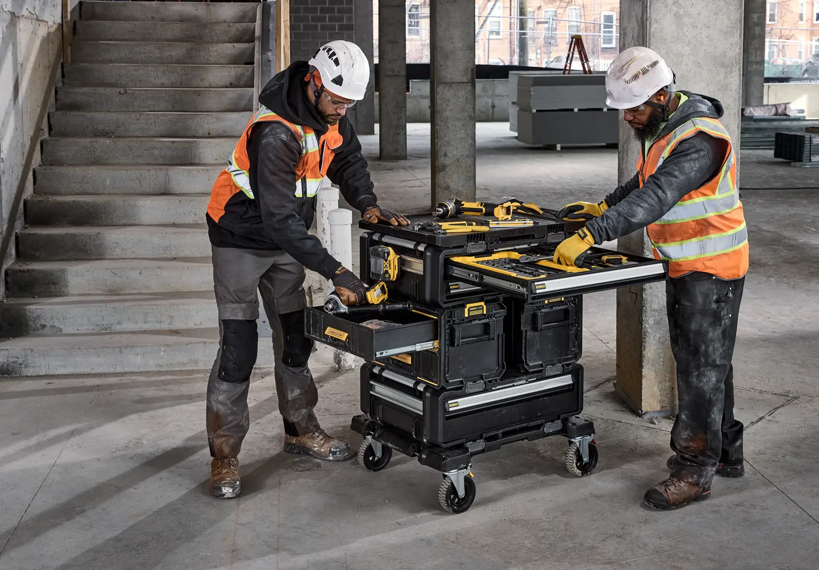 DEWALT DWST60510-1 mobile tool storage cart with drawers and trays in use at a construction site.