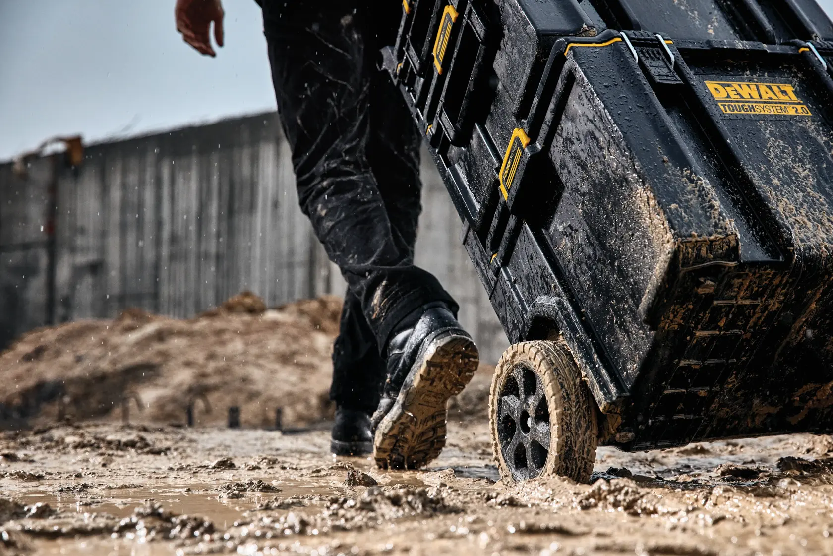 DEWALT ToughSystem 2.0 Werbegrafik mit dem Slogan 'Storage Built to Handle It' in großen, gelben Buchstaben auf einem dunklen, strukturierten Hintergrund.
