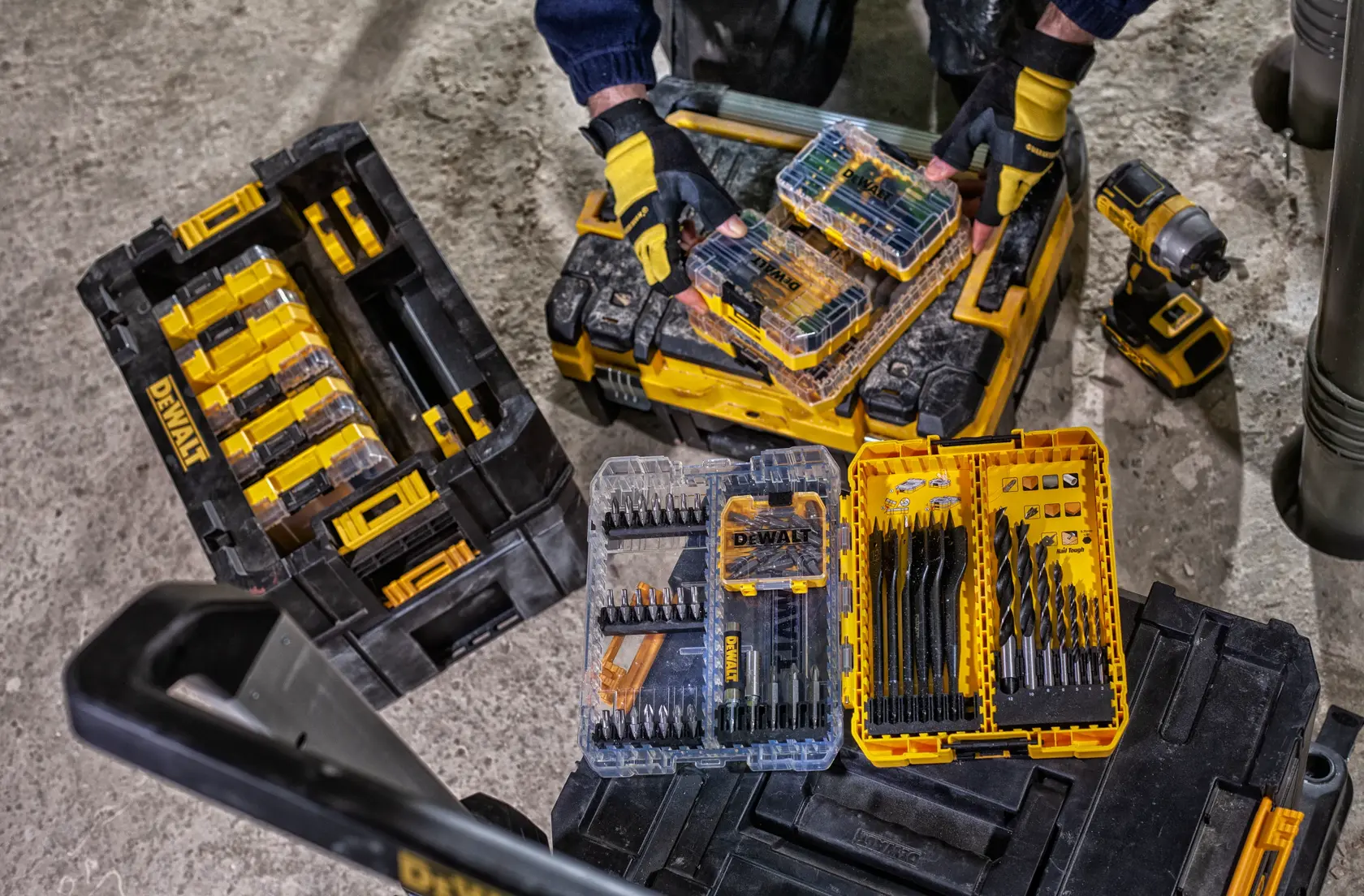 Un chariot utilitaire roulant de marque DEWALT avec deux grandes roues arrière et deux petites roulettes avant, équipé d'une poignée solide et d'une base plate pour transporter des outils ou du matériel.